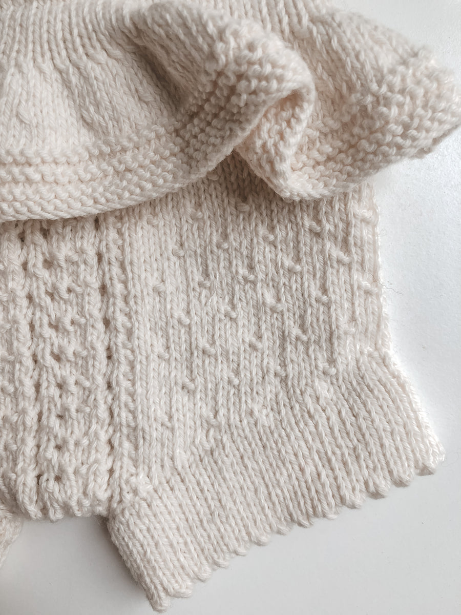 details of frilly lacy hand knit romper